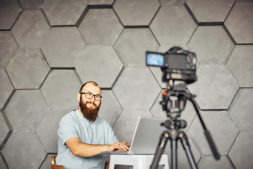The Quiet Power of Starting Small content creation for social media. bearded man shooting video of himself using camera on tripod. modern technology and blogging freelance work concept.